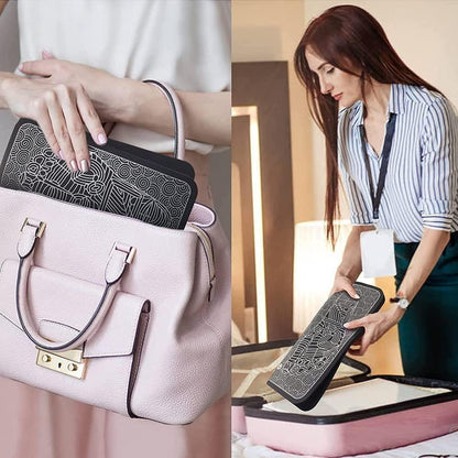 Portable black patterned electronic device for travel placed in pale pink handbag and suitcase.