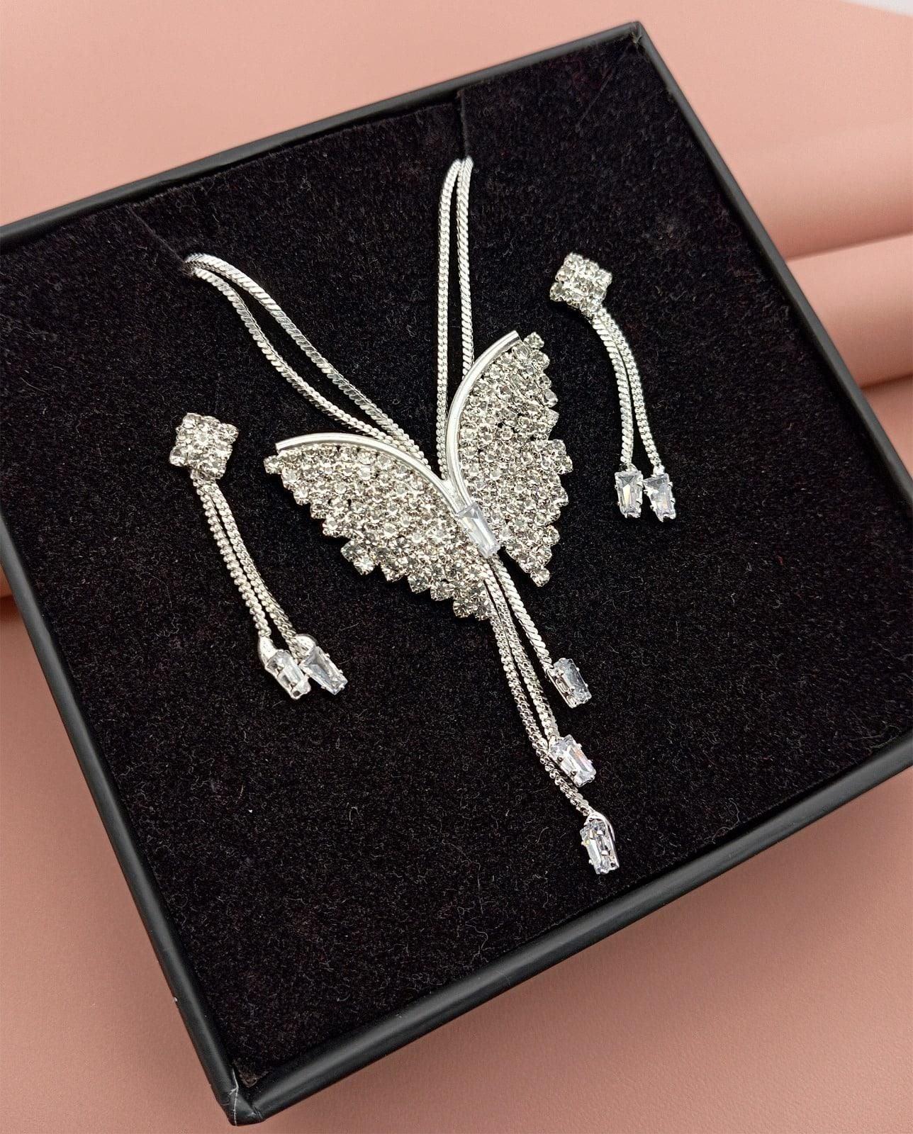 Sparkling butterfly-shaped silver brooch with crystal embellishments and matching earrings in black jewelry box