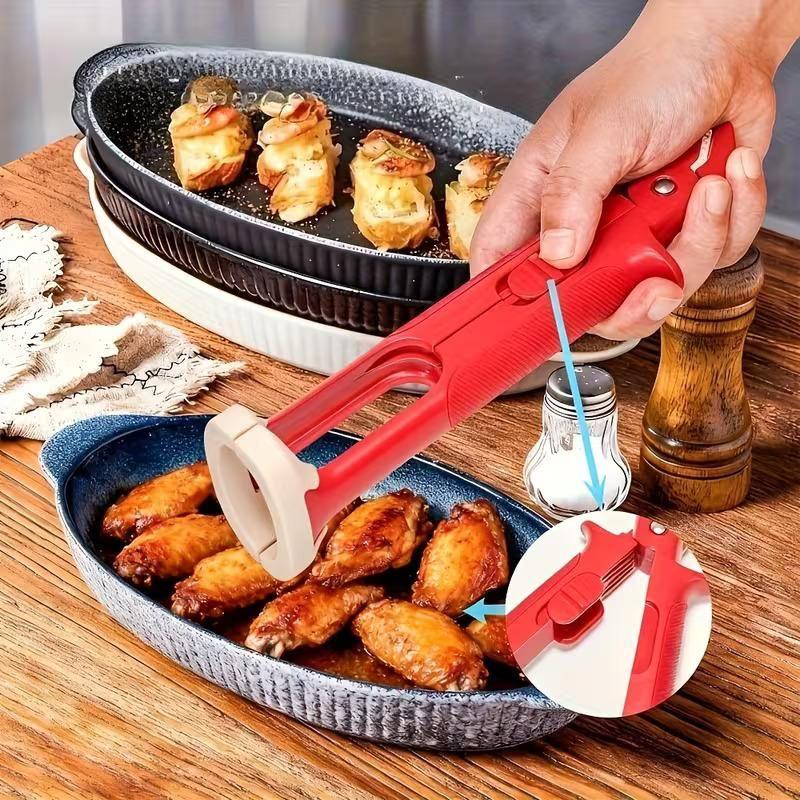 hand holding red kitchen tong picking chicken wings from blue serving dish on wooden table with stuffed appetizers in black dish